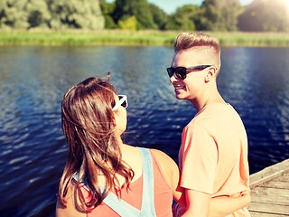 Image showing happy teenage couple sitting on river berth