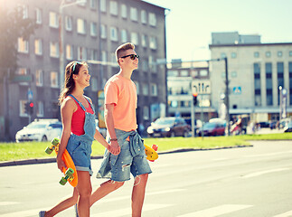 Image showing teenage couple with skateboards on city street