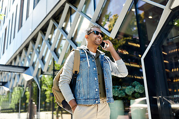 Image showing man with backpack calling on smartphone in city