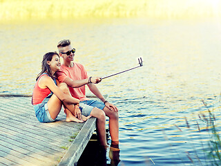 Image showing happy teenage couple taking selfie on smartphone