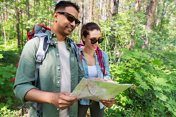 Image showing mixed race couple with map and backpacks in forest