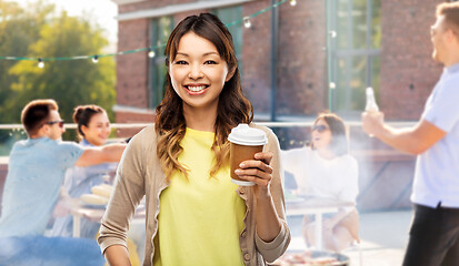 Image showing asian woman drinking coffee over rooftop party