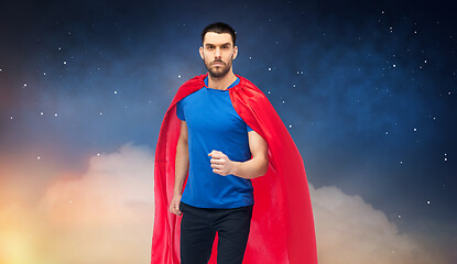 Image showing man in red superhero cape over night sky