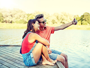 Image showing happy teenage couple taking selfie on smartphone