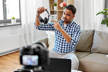 Image showing male blogger with headphones videoblogging at home