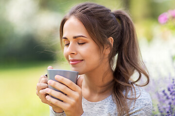 Image showing woman drinking tea or coffee at summer garden
