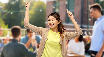 Image showing happy asian woman dancing over rooftop party