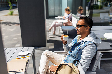 Image showing indian man drinking coffee at city street cafe