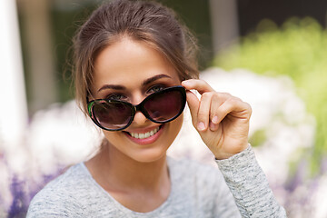 Image showing happy young woman in sunglasses at summer garden