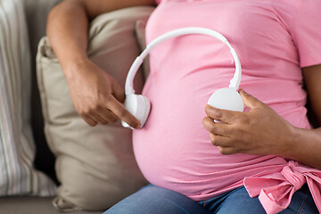 Image showing pregnant woman with headphones on her belly