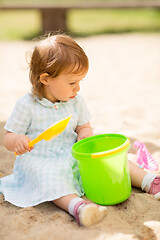 Image showing little baby girl plays with toys in sandbox