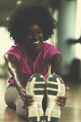 Image showing woman in a gym stretching and warming up before workout