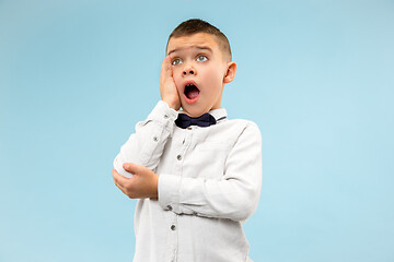 Image showing The young attractive teen boy looking suprised isolated on blue