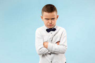 Image showing The young emotional angry teen boy on blue studio background