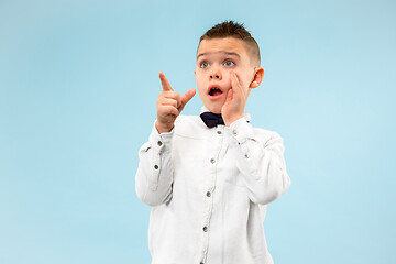 Image showing The young attractive teen boy looking suprised isolated on blue