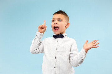 Image showing The young attractive teen boy looking suprised isolated on blue