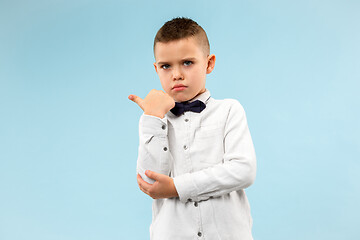 Image showing The teen boy whispering a secret behind her hand over blue background