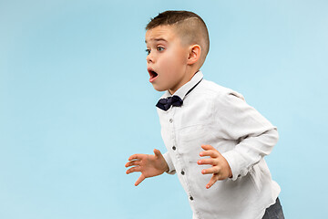 Image showing The young attractive teen boy looking suprised isolated on blue