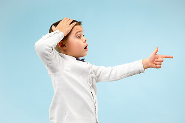 Image showing The young attractive teen boy looking suprised isolated on blue