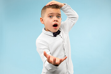 Image showing The young attractive teen boy looking suprised isolated on blue