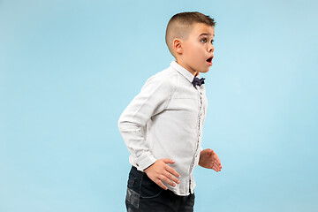 Image showing The young attractive teen boy looking suprised isolated on blue