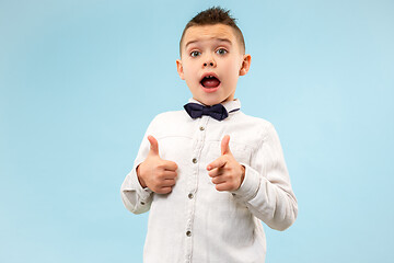 Image showing The young attractive teen boy looking suprised isolated on blue