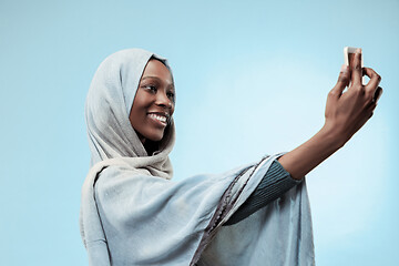 Image showing The beautiful young black muslim girl wearing gray hijab, with a happy smile on her face.