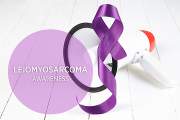 Image showing The purple ribbon on white wooden background