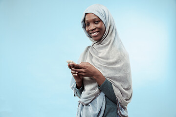 Image showing The beautiful young black muslim girl wearing gray hijab, with a happy smile on her face.