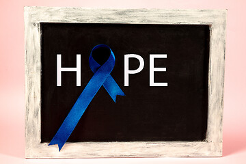 Image showing Colon cancer awareness poster. Blue ribbon made of dots on white background. Medical concept.