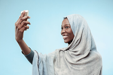 Image showing The beautiful young black muslim girl wearing gray hijab, with a happy smile on her face.