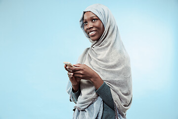 Image showing The beautiful young black muslim girl wearing gray hijab, with a happy smile on her face.