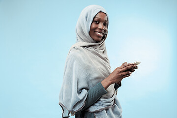 Image showing The beautiful young black muslim girl wearing gray hijab, with a happy smile on her face.