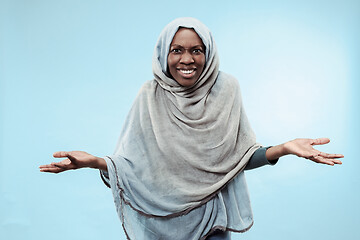 Image showing The beautiful young black muslim girl wearing gray hijab, with a happy smile on her face.