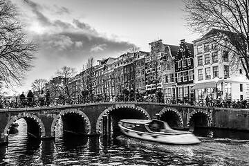 Image showing Beautiful tranquil scene of city of Amsterdam at dusk. Bicycles along the street and on the bridge over the canal.