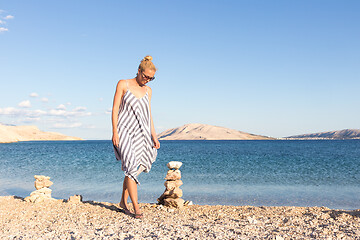 Image showing Happy carefree woman enjoying late afternoon walk on white pabbled beach on Pag island, Croatia