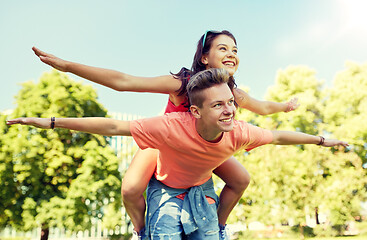 Image showing happy teenage couple having fun at summer park