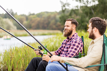 Image showing male friends fishing and drinking beer on lake