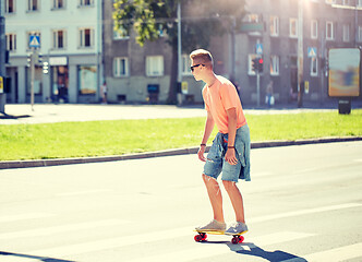 Image showing teenage boy on skateboard crossing city crosswalk