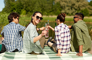 Image showing friends drinking beer and cider on lake pier