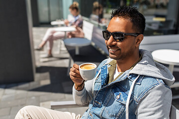 Image showing indian man drinking coffee at city street cafe