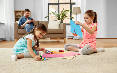 Image showing happy sisters doing arts and crafts at home