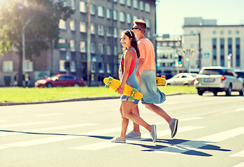 Image showing teenage couple with skateboards on city street