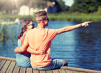 Image showing happy couple pointing finger on summer river berth