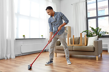 Image showing man with broom cleaning floor at home