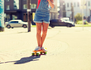 Image showing teenage girl riding skateboard on city street