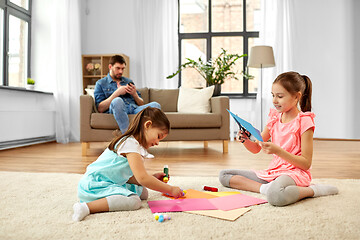 Image showing happy sisters doing arts and crafts at home