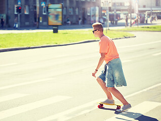 Image showing teenage boy on skateboard crossing city crosswalk