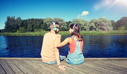 Image showing teenage couple with headphones on river berth