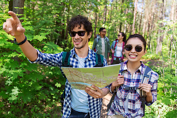 Image showing friends with map and backpacks hiking in forest